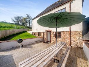 a large green umbrella sitting on a wooden deck at Madeleine - Hja in Luton
