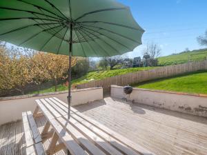 a green umbrella sitting on top of a wooden bench at Madeleine - Hja in Luton