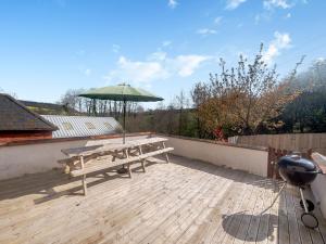 a picnic table with an umbrella on a deck at Madeleine - Hja in Luton