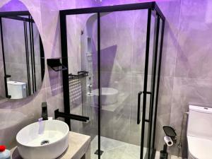 a purple bathroom with a sink and a shower at Annaria in Leptokarya +17 photos