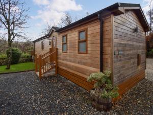 a small wooden cabin with a staircase and a porch at Bluebird Lodge 2 - Uk50932 in High Nibthwaite