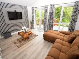 a living room with a couch and a table at Bluebird Lodge 2 - Uk50932 in High Nibthwaite