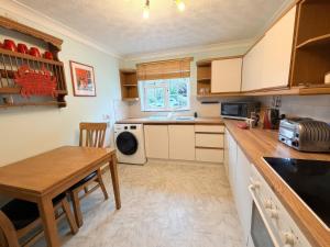 a kitchen with a table and a sink and a microwave at No 1 The Martins in Southwold