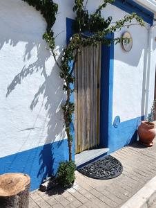 a blue and white house with a wooden door at Casinha das Portas Amarelas in Monsaraz