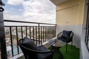 a balcony with two chairs and a table and a view at Studio Apartment with balcony in Ngara in Nairobi