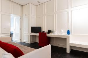 a bedroom with a bed and a desk with a television at Villa Ascosa - Relais sul Mare in Trani
