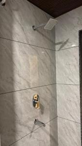 a shower in a bathroom with a tile floor at Hotel Gatik Inn in Sānāwad