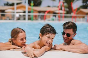 a group of three people in a swimming pool at Suites & Villas by Dunas in Maspalomas