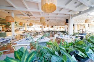 a restaurant with tables and potted plants at Suites & Villas by Dunas in Maspalomas