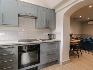 a kitchen with gray cabinets and a dining room at Foxglove in Bicester
