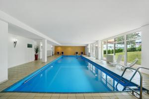 a swimming pool with blue water in a building at Schanzenblick mit Sauna und Pool in Schönwald