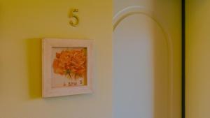 a picture of roses on a wall with a clock at Corte Pulchra - Italian Homing in Pozzolengo +112 photos