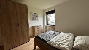 a bedroom with a bed and a dresser and a window at Ferienwohnung Bickenalb in Zweibrücken