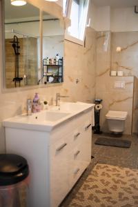 a bathroom with a white sink and a toilet at Apartman NOA in Novska