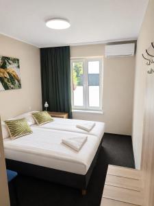a large bed in a room with a window at Samoobsługowy Hotel Astoria Fly Modlin Airport in Pomiechówek