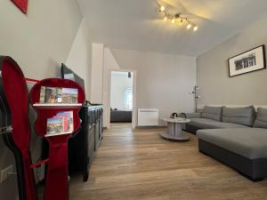 a living room with a couch and a tv at Le Cosy Industriel in Le Puy-en-Velay