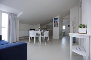 ein weißes Wohnzimmer mit Tisch und Stühlen in der Unterkunft Path House by Wonderful Italy in Riposto