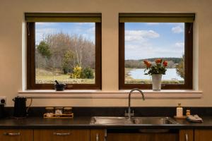 two windows above a kitchen sink with a view of a lake at Lakeside Lodge, Views, Hot Tub & Fully Accessible in Elgin