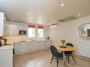 a kitchen with a table and chairs in a kitchen at Poppy Patch in Bicester