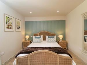 a bedroom with a large bed and two night stands at Poppy Patch in Bicester