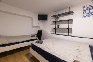 a bedroom with two beds and shelves on the wall at AISHA Hostel in Ljubljana