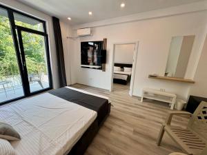 a bedroom with a bed and a large window at Mimar Boutique in Eforie Sud