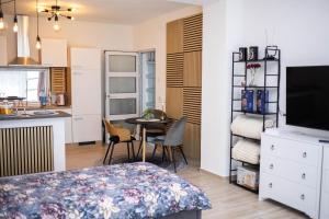 a room with a kitchen and a table with chairs at Apartman NOA in Novska
