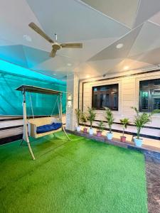 a porch with a swing and a green carpet at Riddhihomestay in Jaipur