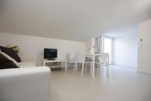 ein weißes Wohnzimmer mit Tisch und Stühlen in der Unterkunft Path House by Wonderful Italy in Riposto