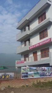a building with a sign on it next to the water at Hotel Himalayan Inn, khona in Pātan
