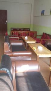 a room with wooden tables and chairs and benches at Hotel Himalayan Inn, khona in Pātan