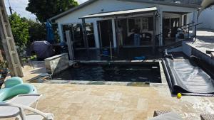 a swimming pool in a backyard with a house at Entre Mer et Volcan ,piscine chauffée au tampon in Bel Air