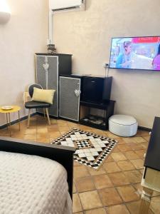a room with a bed and a tv and a chair at Marieta Rooms in Sarzana
