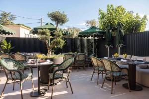 a patio with tables and chairs and green umbrellas at The Fiction in Athens
