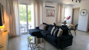 a living room with a blue couch and a table at Kos Cozy Home in Platánion