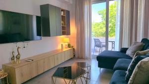 a living room with a couch and a tv at Kos Cozy Home in Platánion