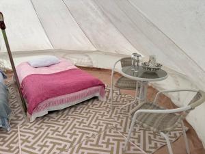 a room with a table and chairs and a tent at Pear Tree Bell tent in Charlton
