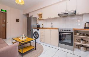 a kitchen with white cabinets and a table in a room at Rocabella Home in Kriopigi +13 photos