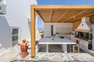 a kitchen with a white table and a white counter top at Crystal Dream Paros in Kampos Paros