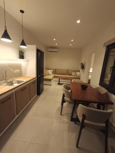 a kitchen and living room with a table and a couch at IOVI Tinos II in Agios Sostis
