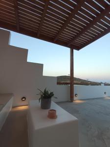 a white table with a potted plant on top of a building at IOVI Tinos II in Agios Sostis