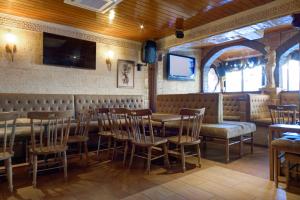 a restaurant with tables and chairs and a tv on the wall at Choromar Apartments in Albufeira