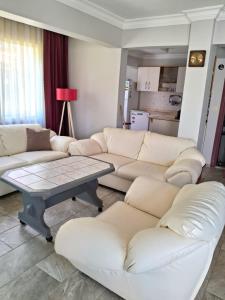 a living room with white couches and a table at Sea View Villa w Garden 50m to Sarımsaklı Beach in Ayvalık