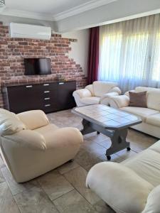 a living room with two couches and a tv at Sea View Villa w Garden 50m to Sarımsaklı Beach in Ayvalık