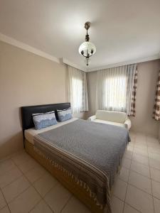 a bedroom with a bed and a couch in it at Sea View Villa w Garden 50m to Sarımsaklı Beach in Ayvalık