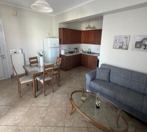 a living room with a couch and a table and a kitchen at Katies cozy corner in Chios +9 photos