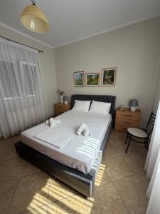 a bedroom with a large white bed and a chair at Katies cozy corner in Chios