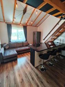 a large living room with a couch and a bar at Zeigių apartamentai in Normantai
