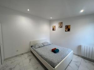 a white bedroom with a bed in a room at Chemin de fer adorable appartement in Gagny