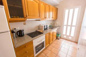 a kitchen with wooden cabinets and a counter top at Oriheula Costa Cabo Roig 5 in Playas de Orihuela